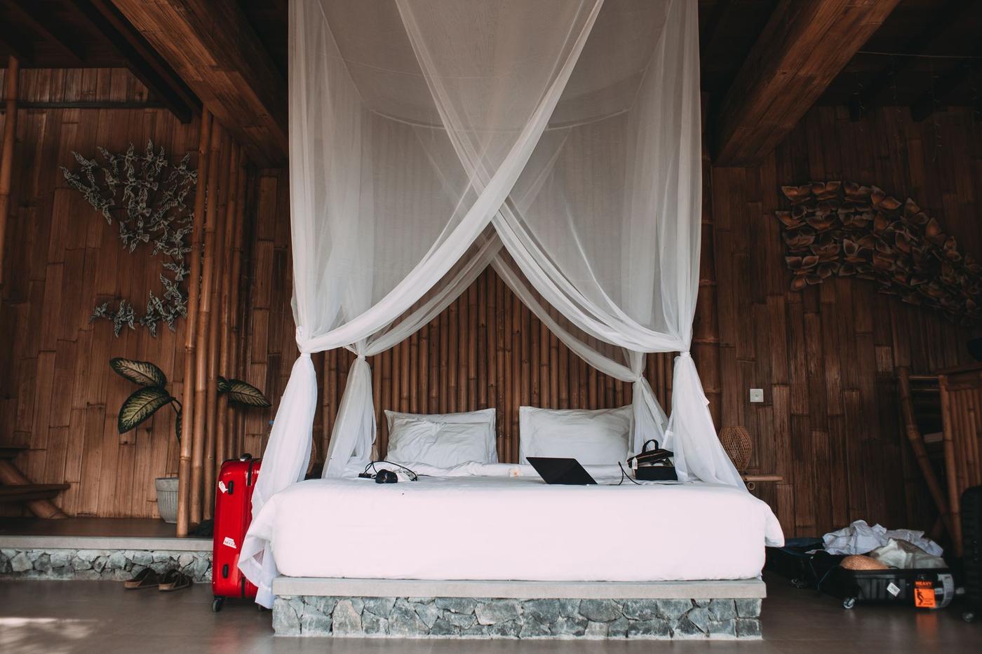 Cama com rede mosquiteira num quarto de madeira
