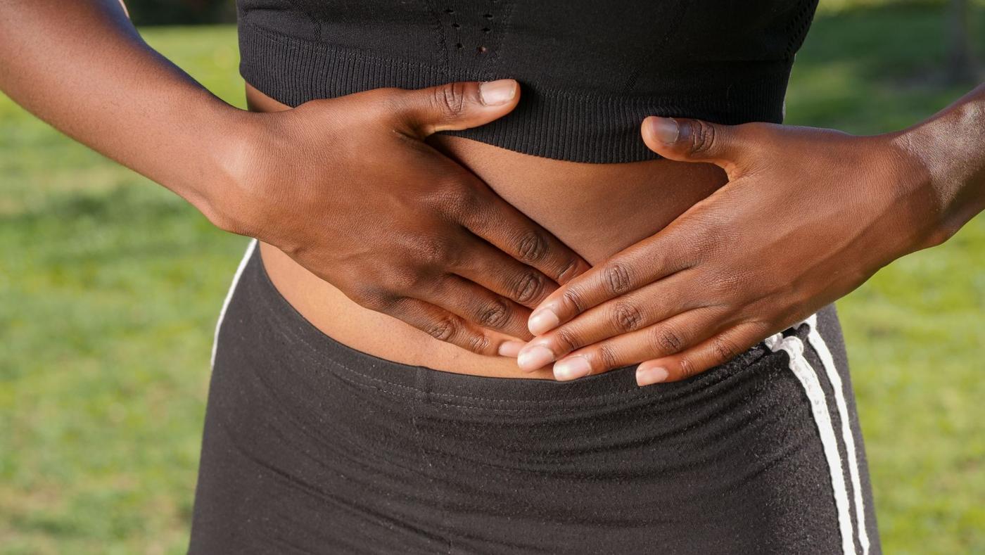 Mulher com as mãos sobre a barriga